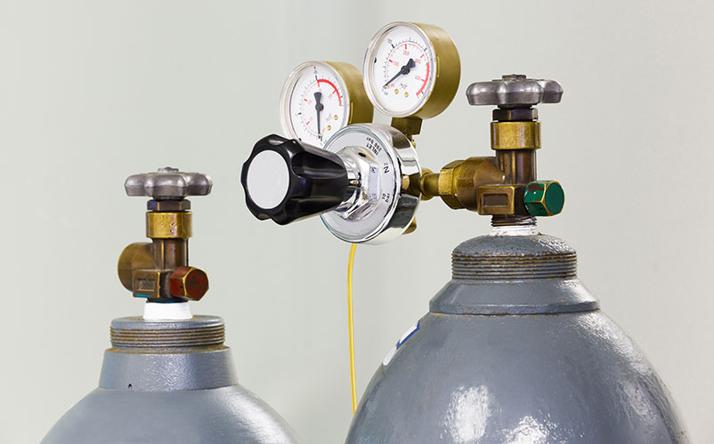 Gas cylinders with pressure regulators and gauges